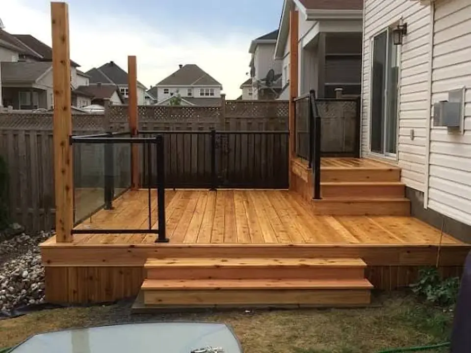 Finished wood deck with black metal railings and wide steps