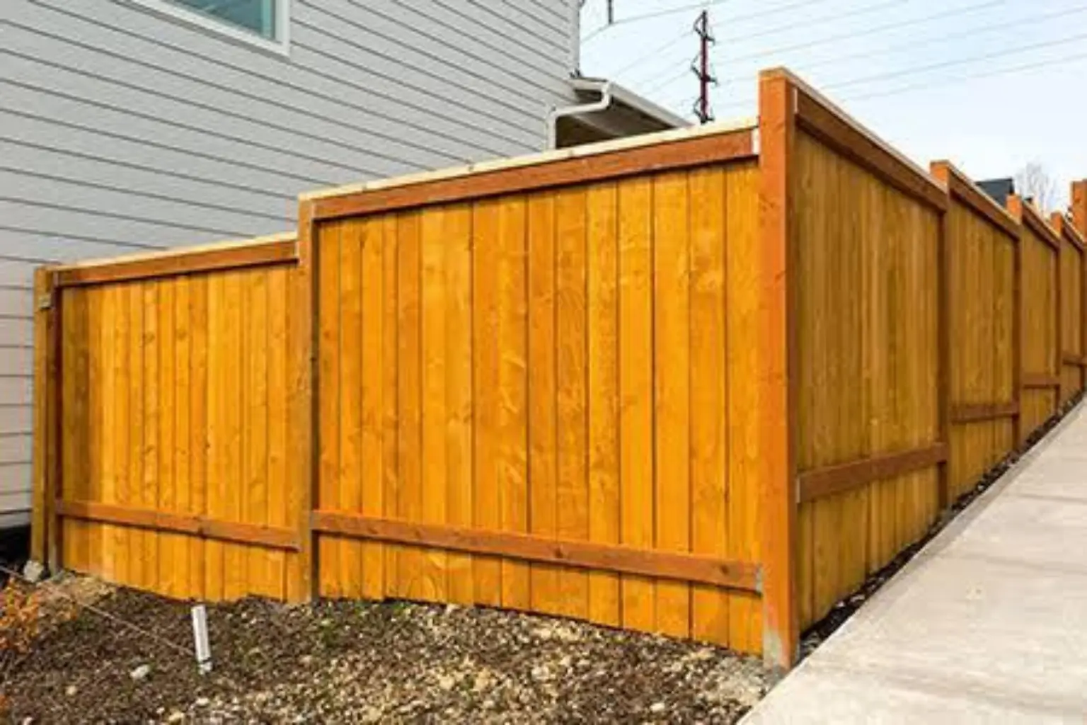 New cedar privacy fence wrapping around the corner of a home