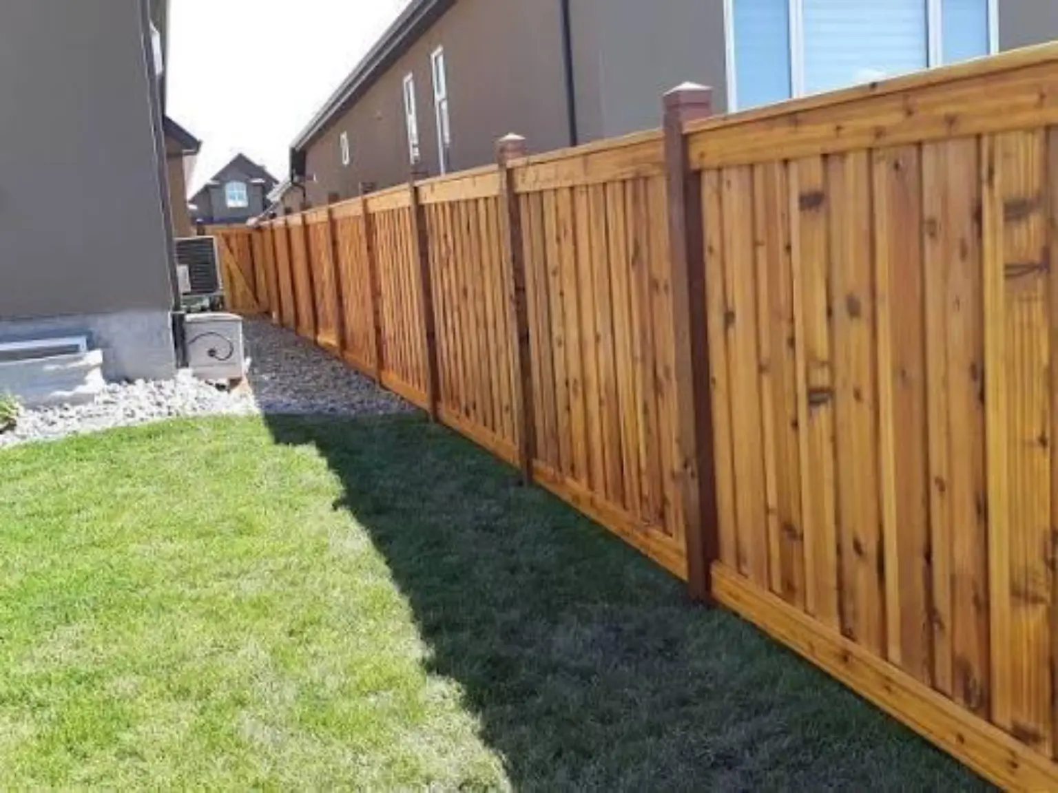 Long finished run of cedar privacy fencing beside a landscaped backyard