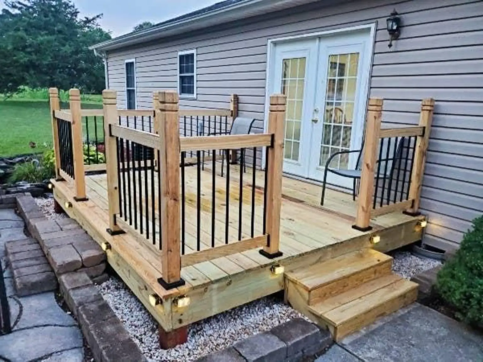 New cedar deck with black metal railings and wide front steps
