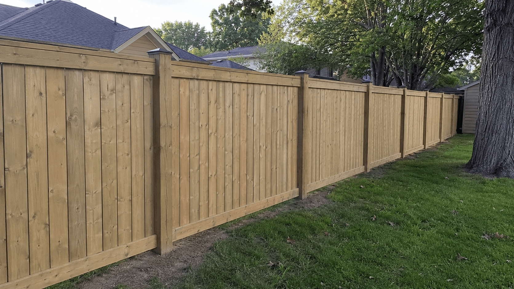 Long run of new wood privacy fencing along a backyard