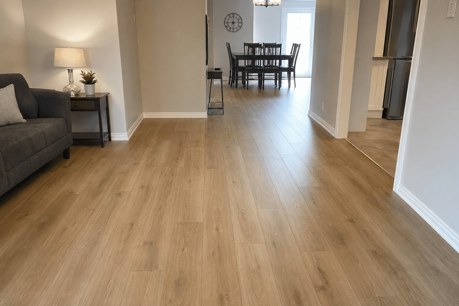 Continuous light wood-look flooring through an open living and dining space