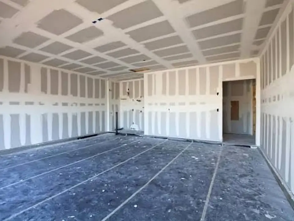 Large garage interior with drywall installation and finishing