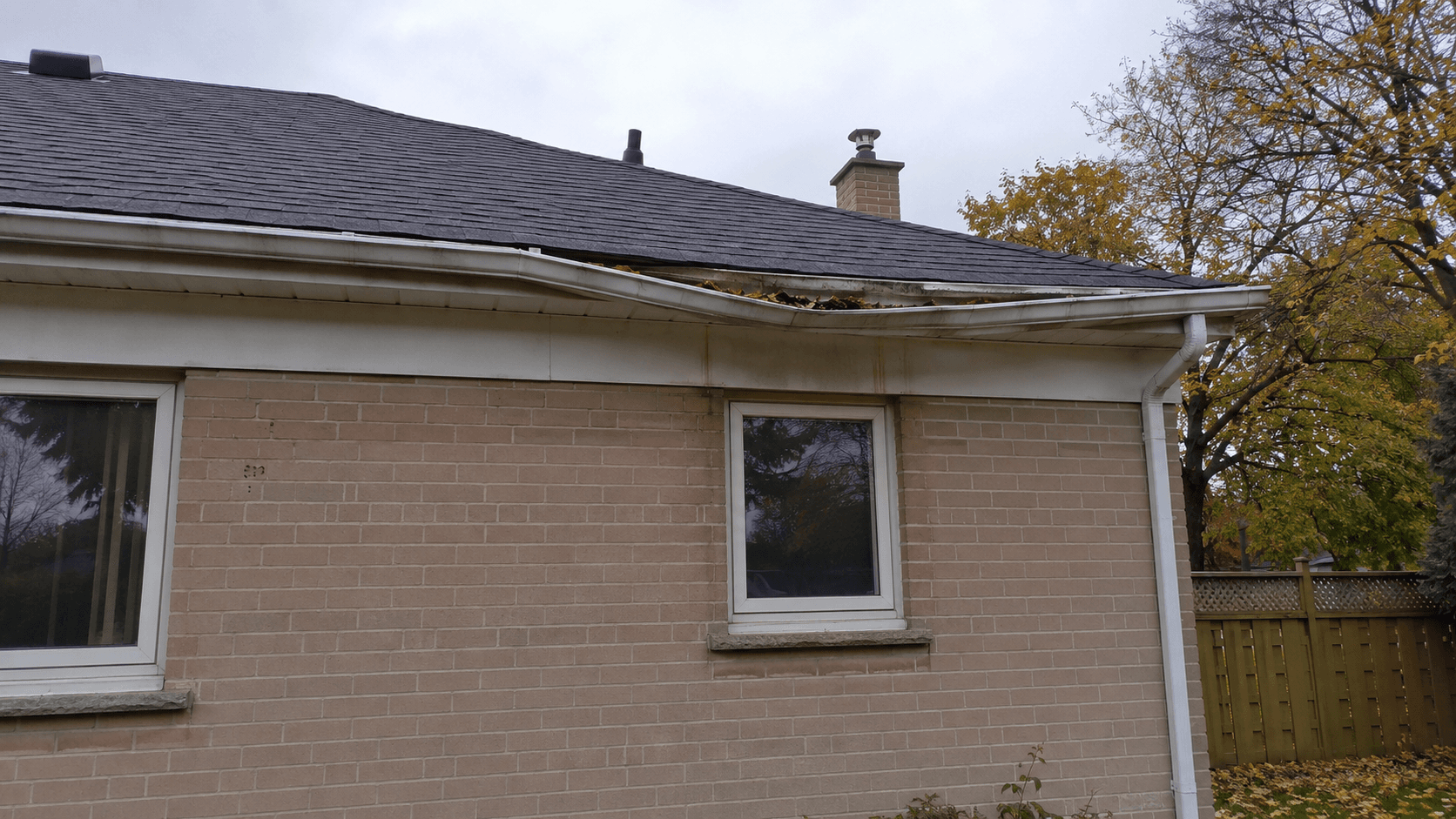 Sagging eavestrough along the roofline of a brick bungalow