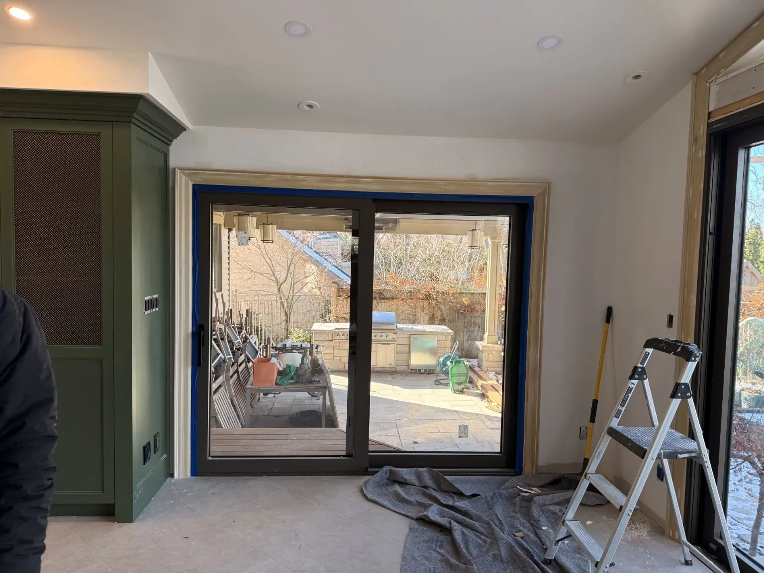 Black sliding patio door with new interior casing in progress