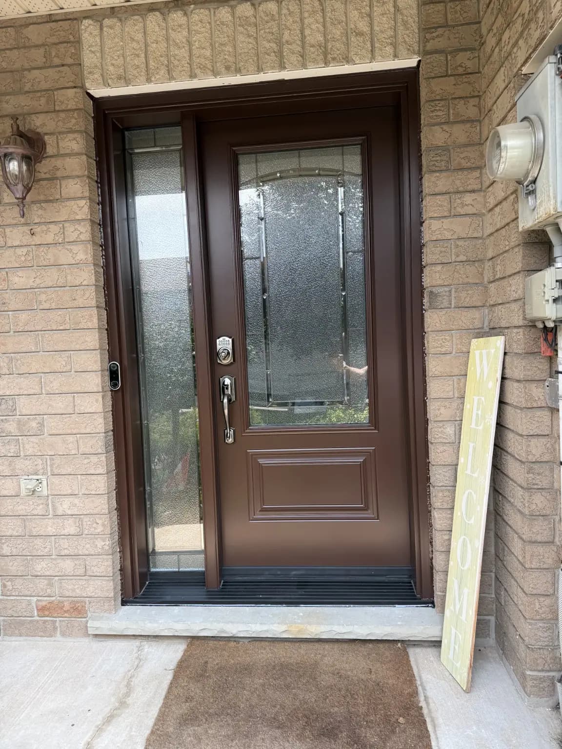 Brown entry door with decorative glass and a matching sidelight