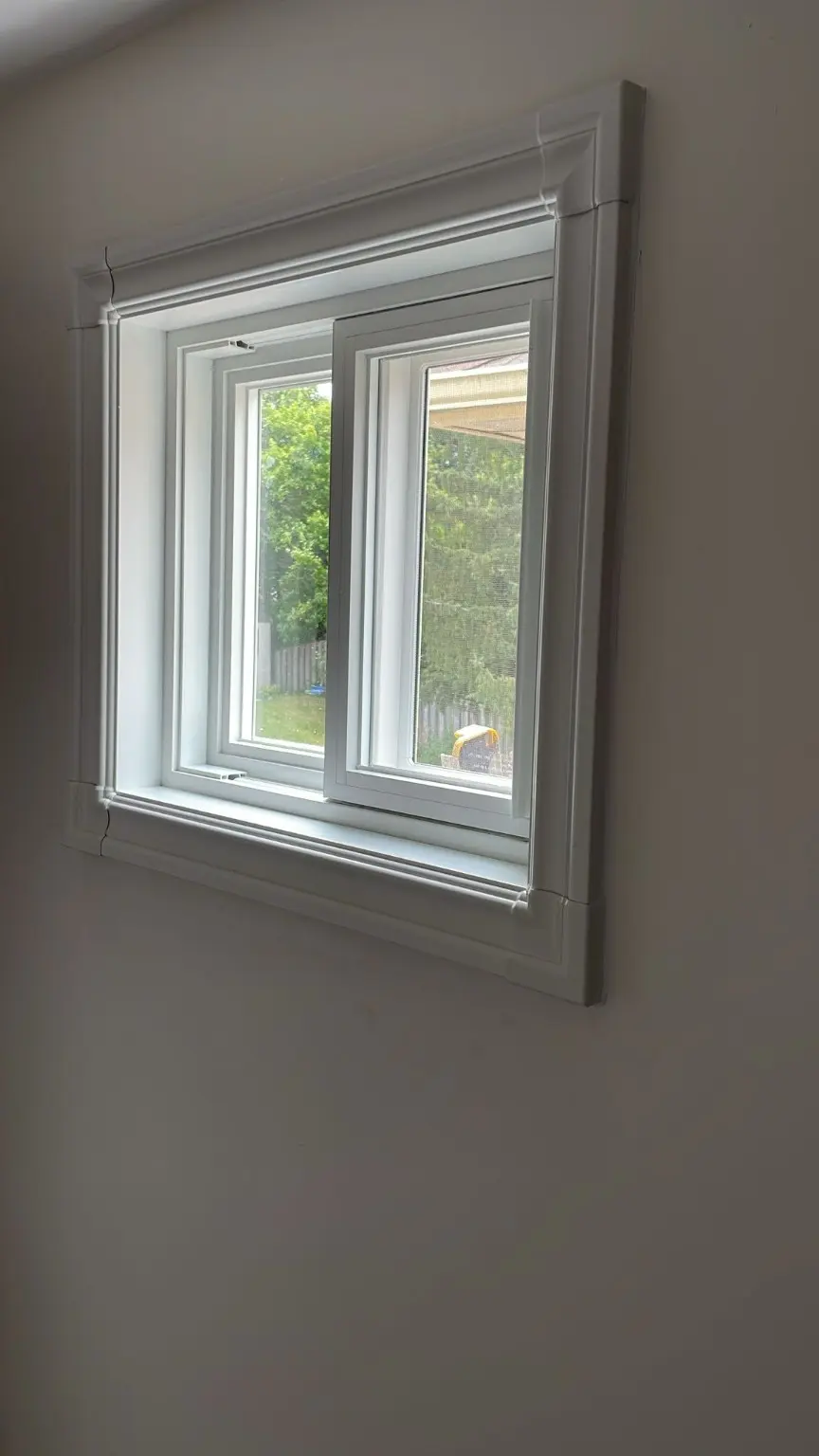 White casement window finished with detailed interior trim