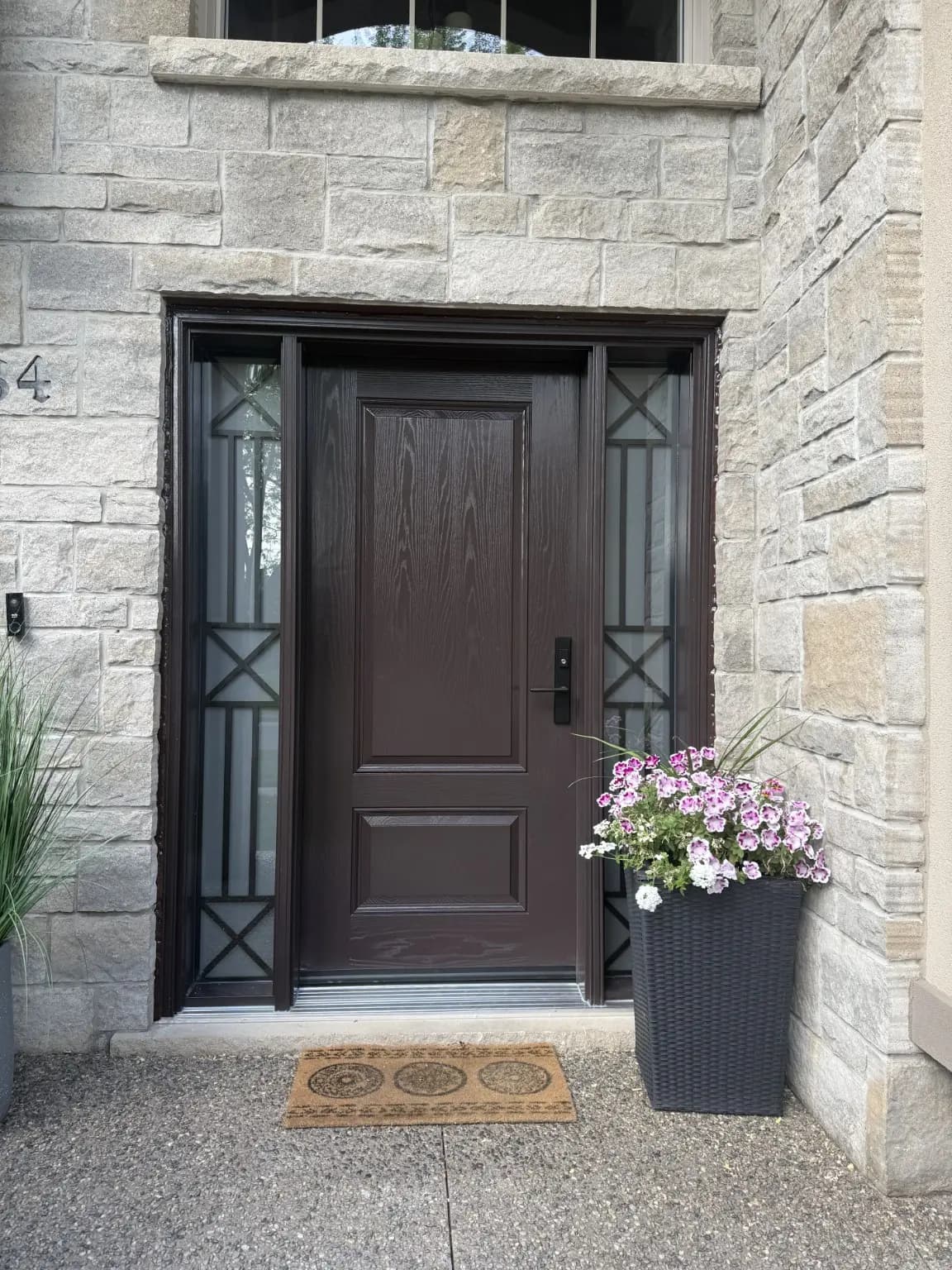 Dark wood-look entry door framed by two decorative sidelights